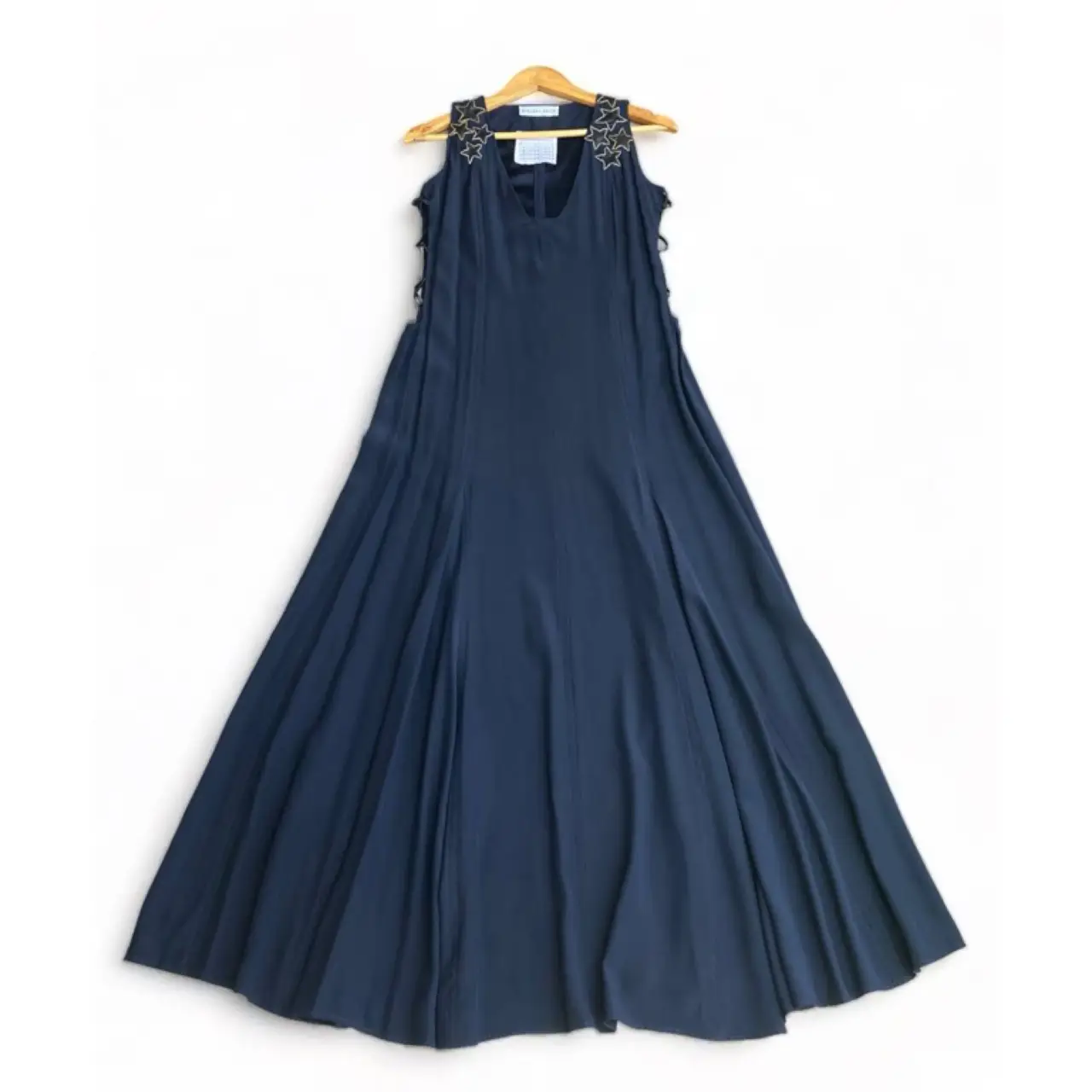 Vestido 100%seda  largo de fiesta en color azul marino, con detalles de estrellas doradas en los hombros y aberturas laterales con cintas. Corte elegante y fluido, ideal para eventos especiales.