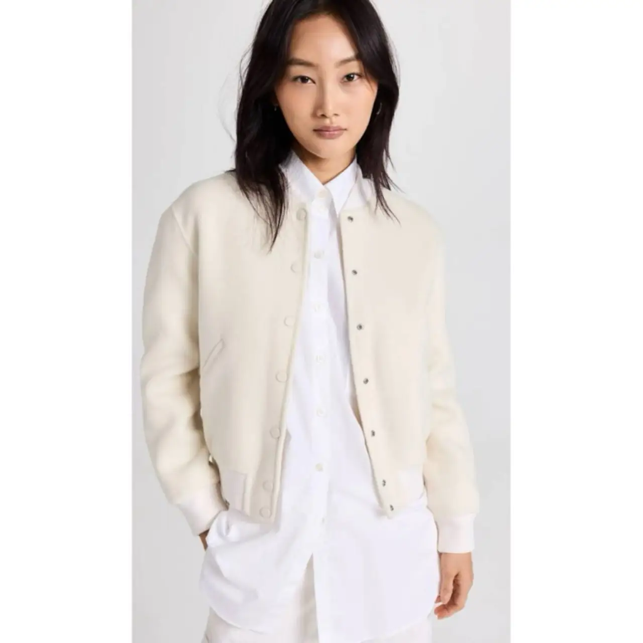 Campera bomber de mujer en color blanco, con cuello y puños tejidos en color rosa claro. Cierre con botones a presión. Ideal para un look casual y moderno.