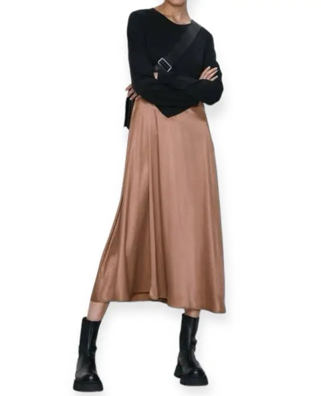 Vestido midi de dos piezas, con la parte superior negra de manga larga y la falda en color marrón. Ideal para un look elegante y moderno.