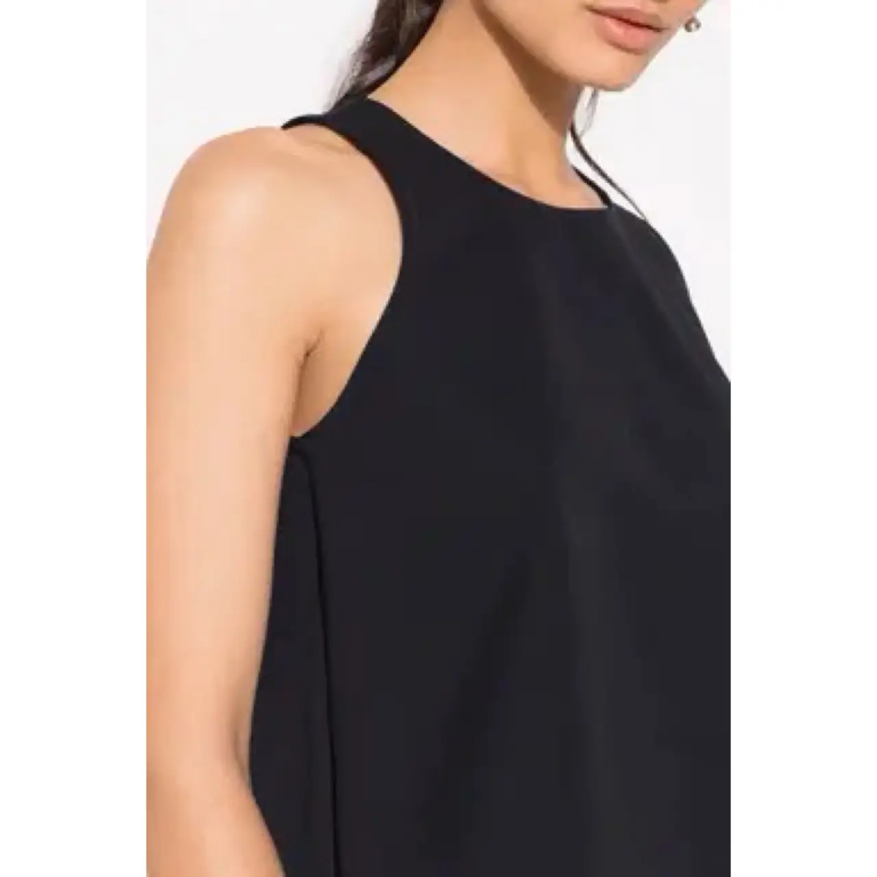 Blusa negra sin mangas, con cuello redondo y cierre en la espalda. Ideal para un look elegante y versátil.