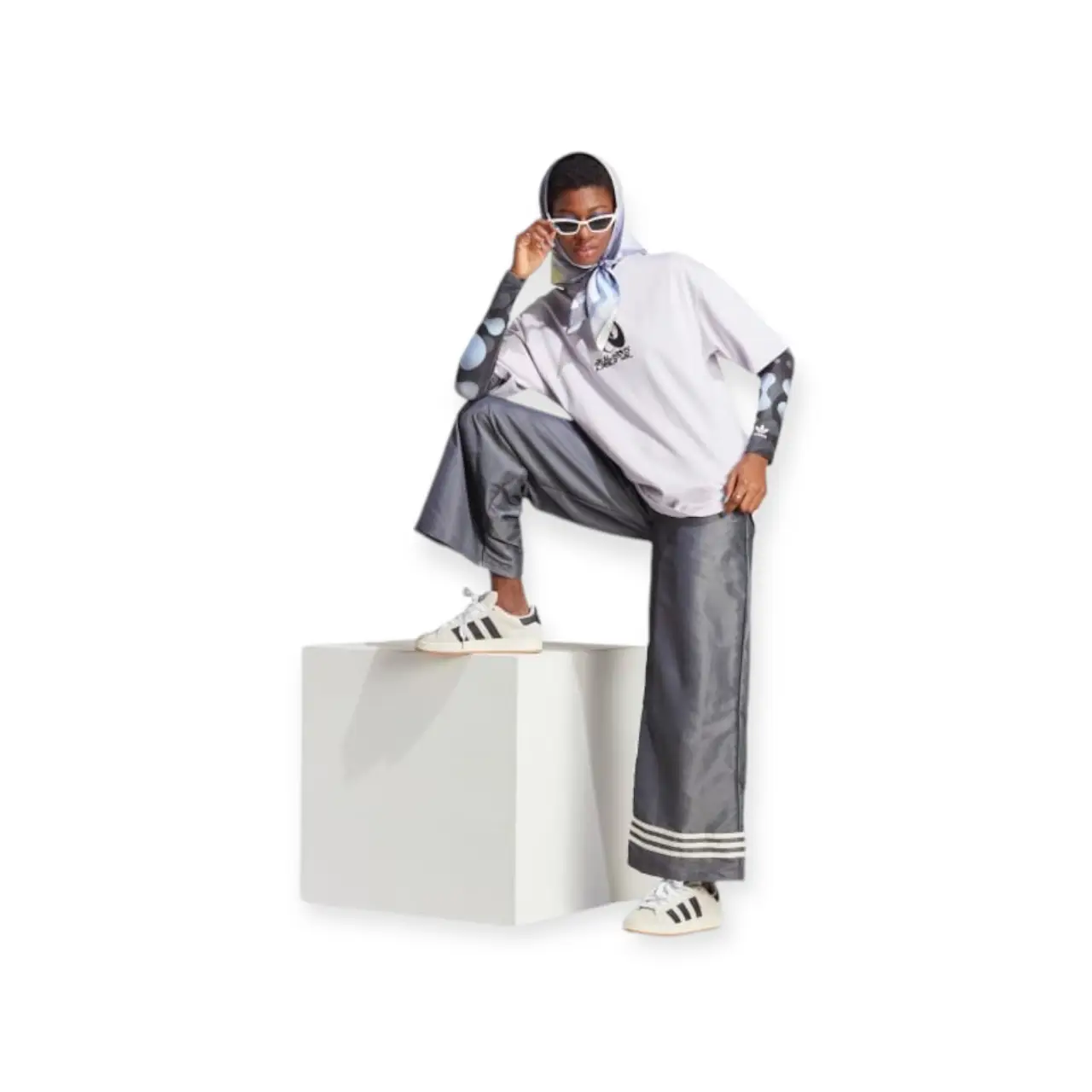 Pantalón marca “Adidas original” suelto de mujer, color gris con detalles de tres líneas blancas en el borde inferior. Ideal para un look casual y moderno.