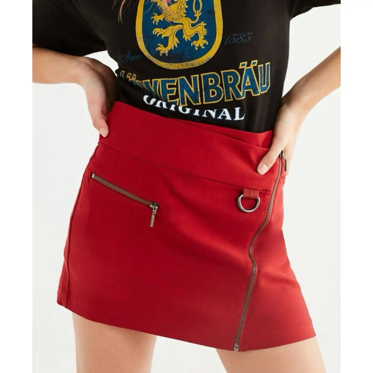 Minifalda roja con cierre diagonal y detalle de aro. Ideal para un look moderno y audaz.