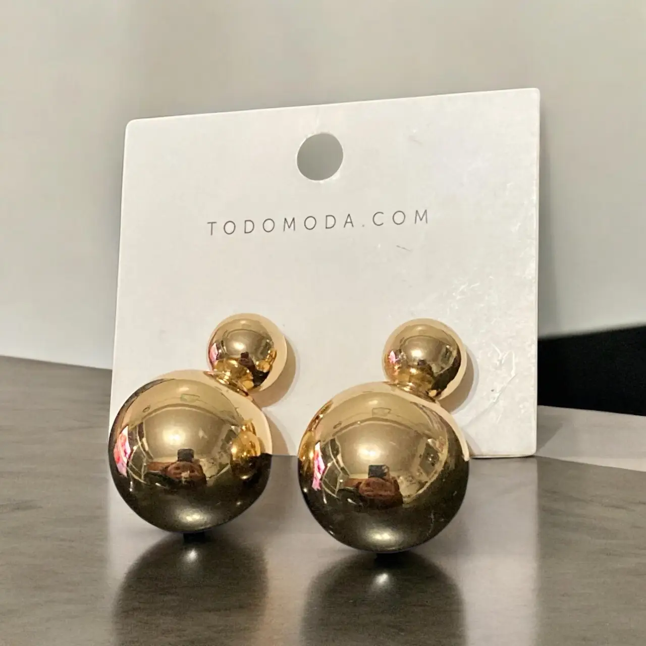 Aros de mujer dorados con forma de esfera doble, estilo moderno y elegante. Perfectos para complementar cualquier look.
