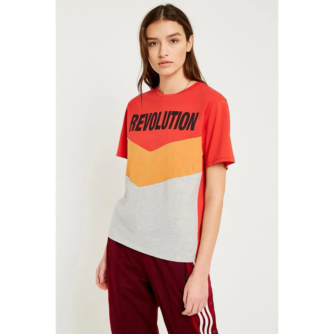 Remera de mujer con diseño "Revolution" en bloques de color. Corte clásico, manga corta y cuello redondo. Ideal para un look casual y moderno.