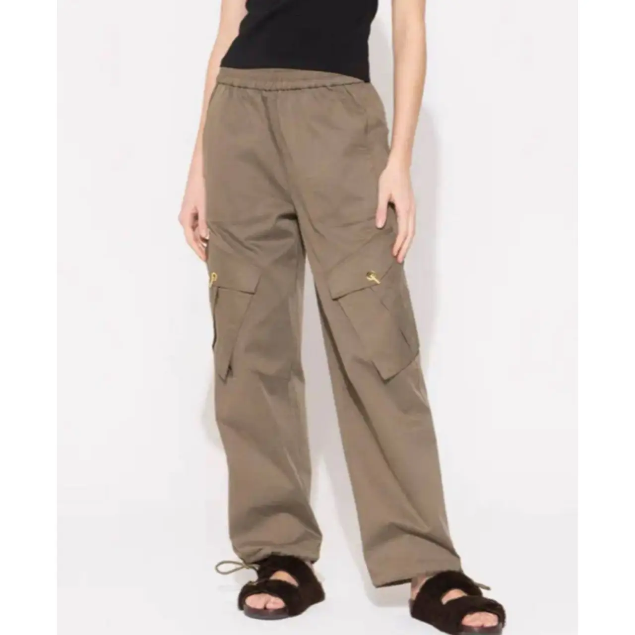 Pantalón cargo de mujer, color marrón. Con bolsillos laterales y detalles dorados. Ideal para un look casual y moderno.