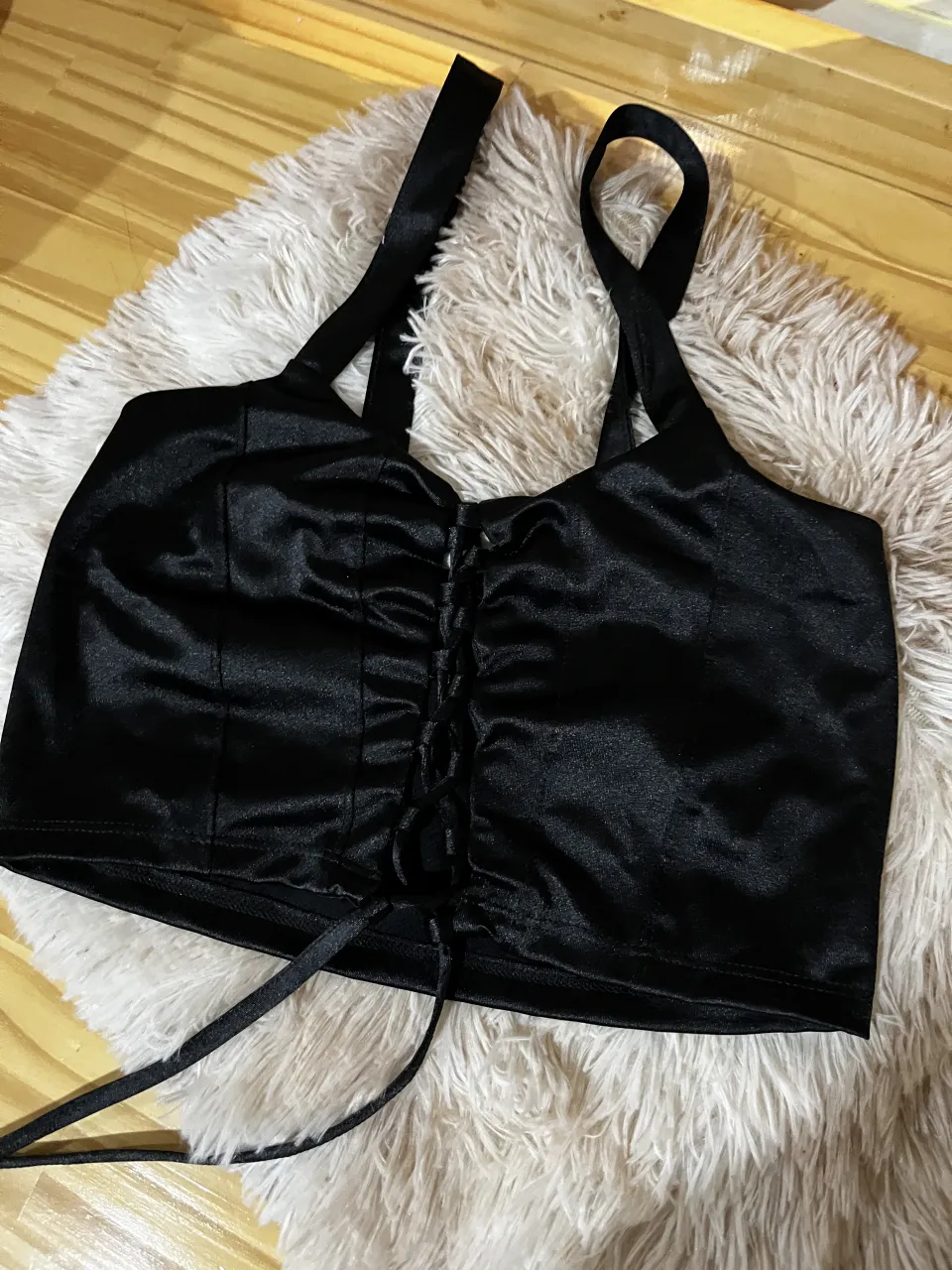 Top negro de satén con cordones y fruncido al frente. Ideal para looks de noche o fiestas.
Un uso 