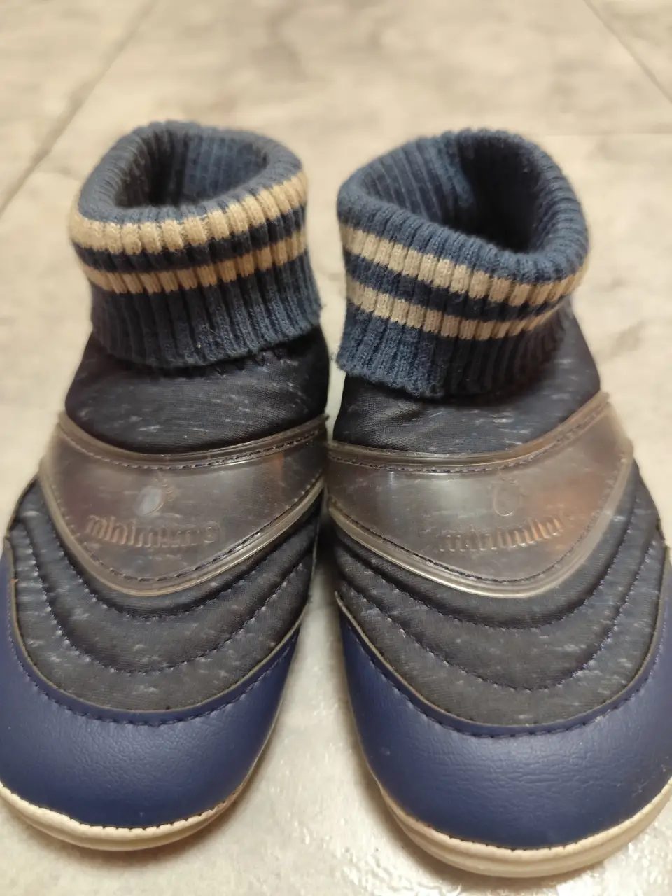 Botitas de bebé azules con detalles en blanco y beige. Diseño cómodo y abrigado, ideal para los primeros pasos. Marca Mimo & Co.