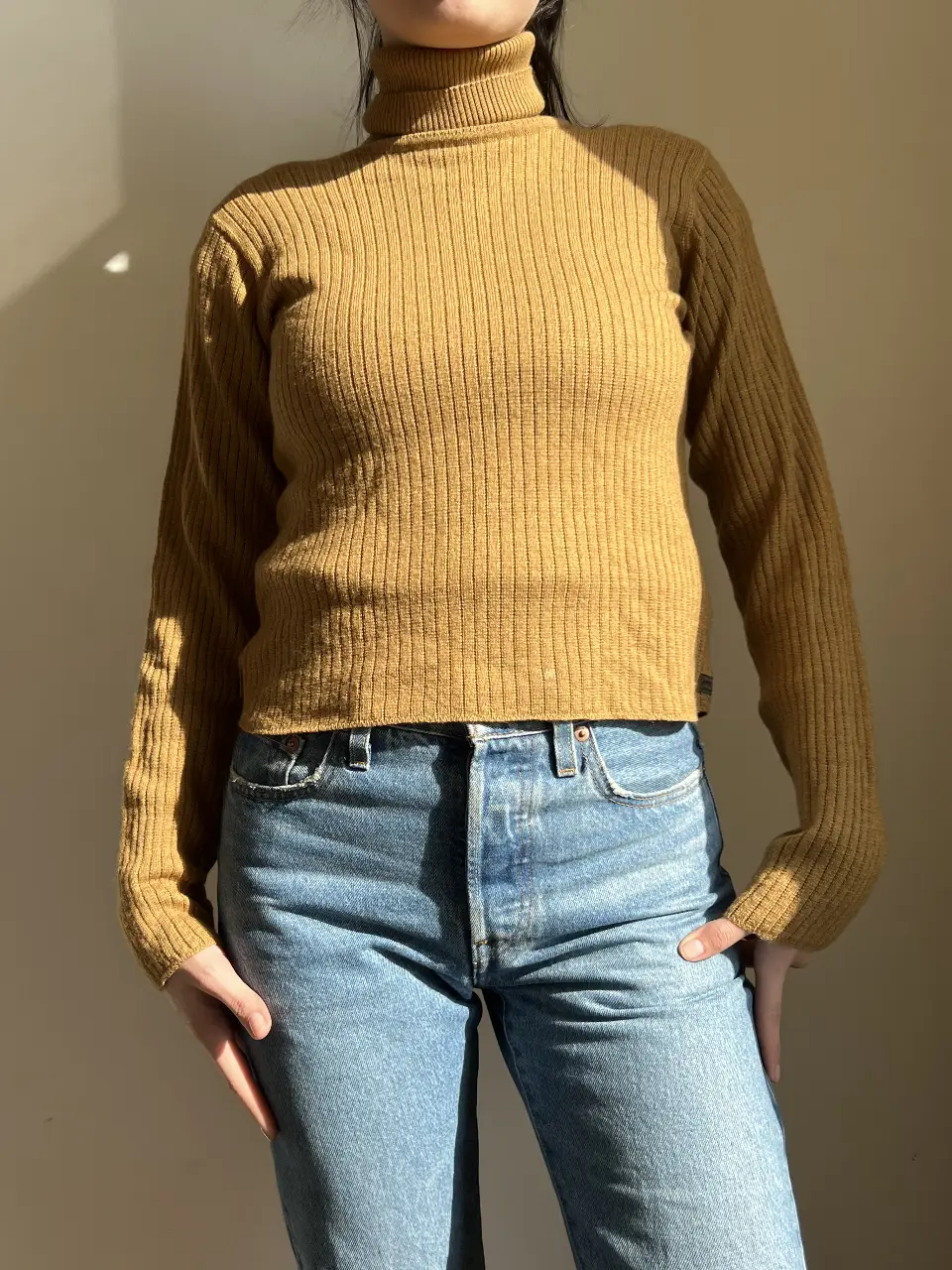 Sweater de cuello alto de punto acanalado en color mostaza. Ideal para un look casual y abrigado.