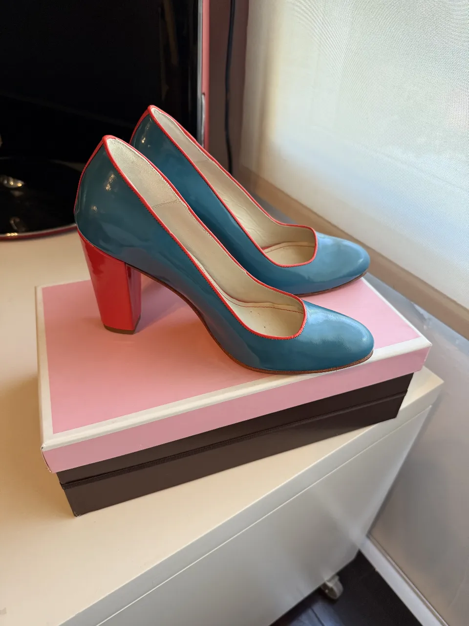 Elegantes zapatos de tacón alto para mujer, en charol azul con detalles en rojo. Ideales para eventos formales o para darle un toque sofisticado a cualquier look.