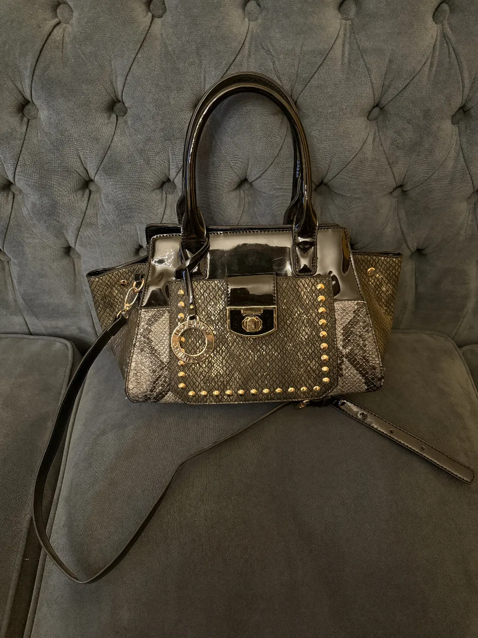 Cartera de mano con detalles dorados y correa para colga corta, Ideal para salidas y eventos. Animal print símil reptil. combinada con charol. super elegante