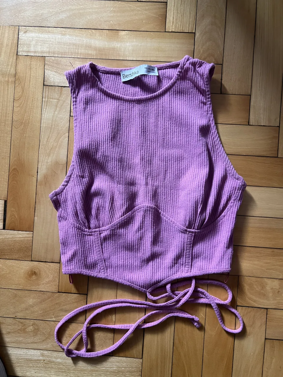 Top de morley color rosa/lila con tiras para atar en la espalda. Escote redondo y sin mangas.