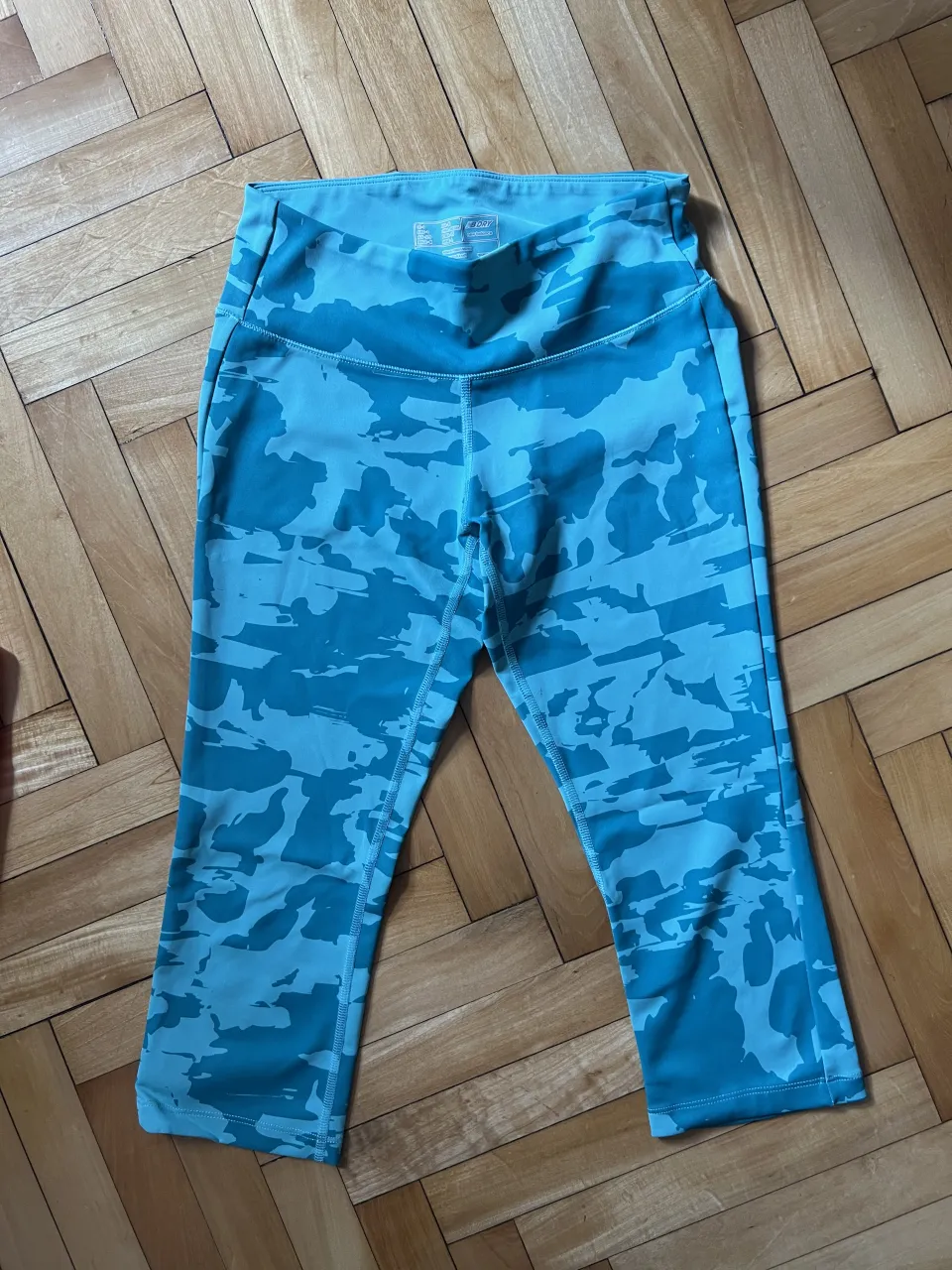 Calzas deportivas cortas con estampa camuflada en tonos celestes y turquesas. Cintura ancha.