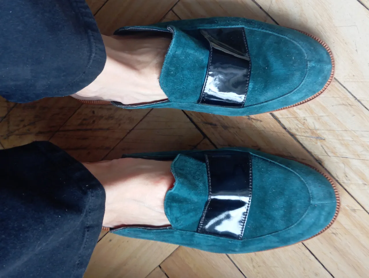Zuecos de gamuza verde con detalle de charol negro. Un calzado elegante y cómodo para un look casual o semi formal. Perfectos para combinar con jeans o pantalones de vestir.