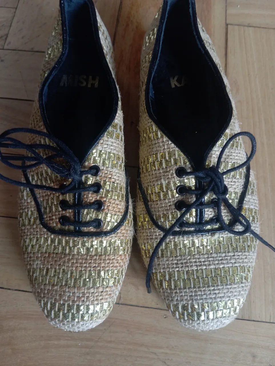 Zapatos de mujer estilo Oxford, con diseño tejido en tonos dorados y detalles en negro. Ideales para un look elegante y moderno.