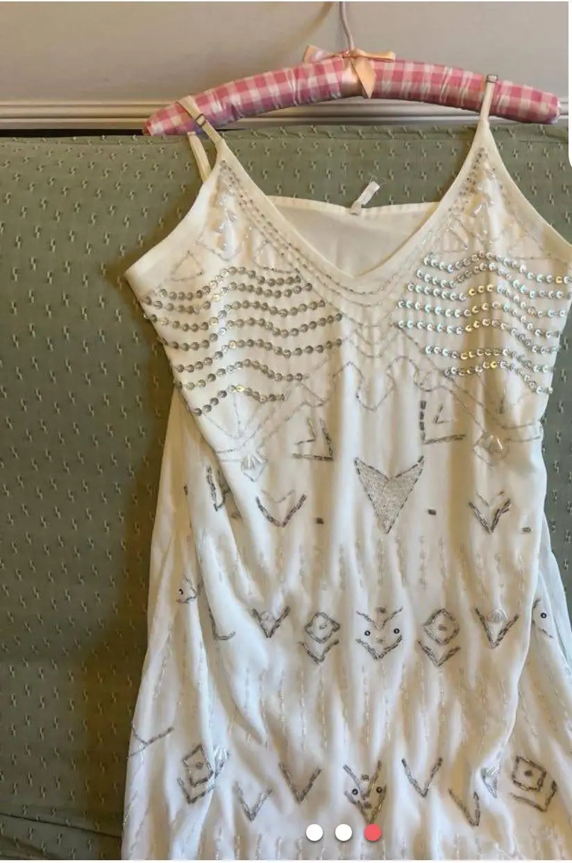 Vestido mini blanco con detalles plateados y lentejuelas. Ideal para fiestas y eventos especiales. Diseño elegante y moderno.