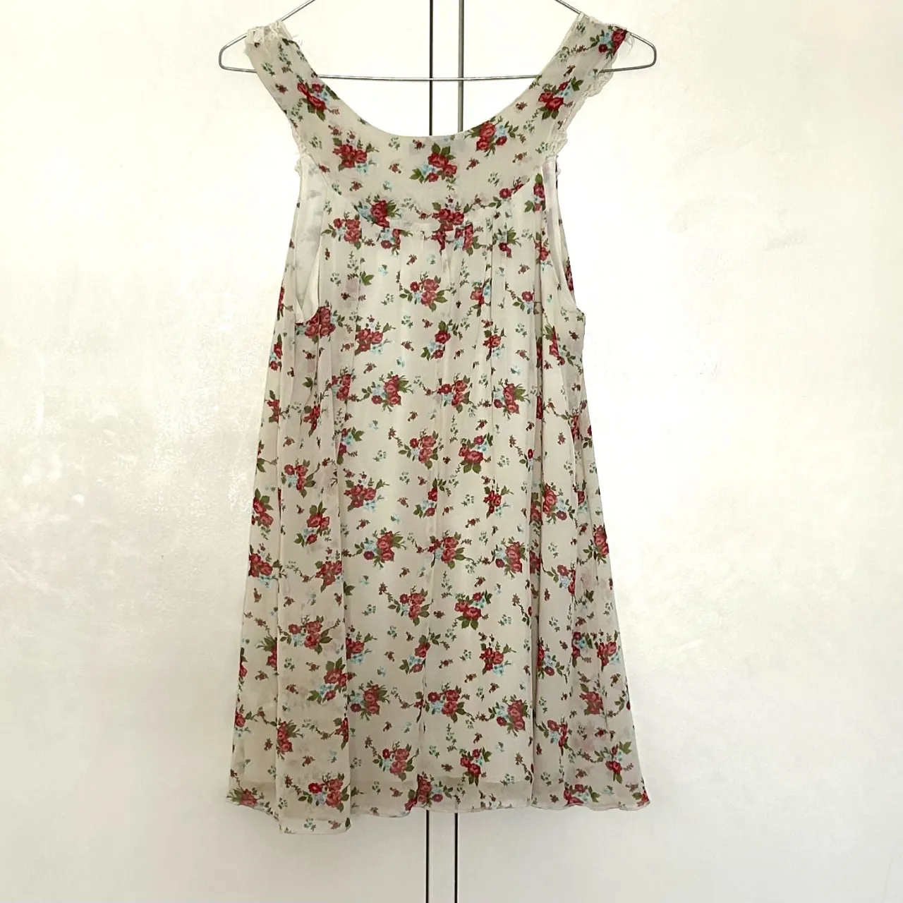 Vestido mini de Forever 21, con estampado floral en tonos rojos y detalles de encaje en el cuello. Ideal para un look fresco y romántico.