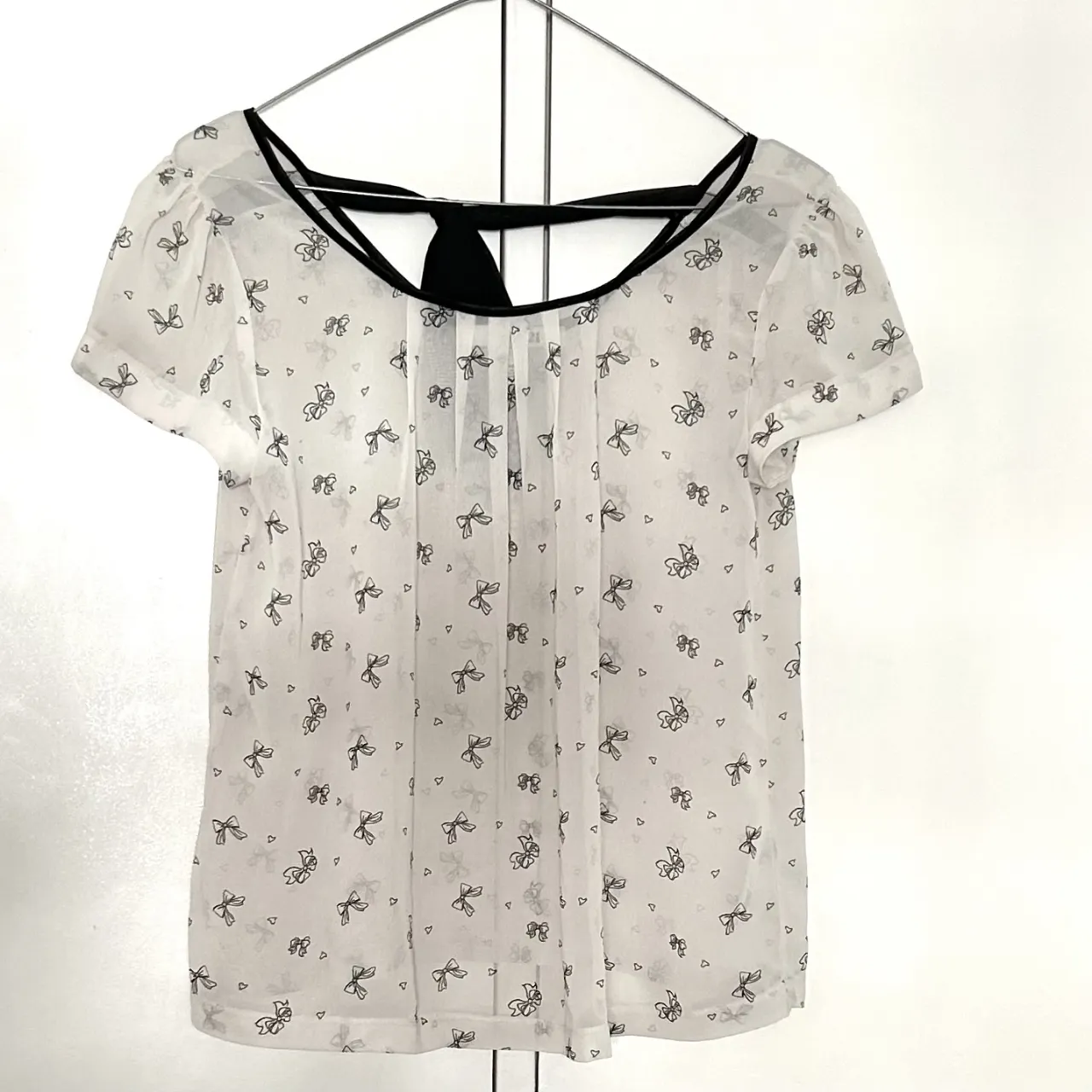 Blusa de mujer Forever 21, blanca con estampado de moños negros. Detalles en negro en el cuello y la espalda. Talle S.