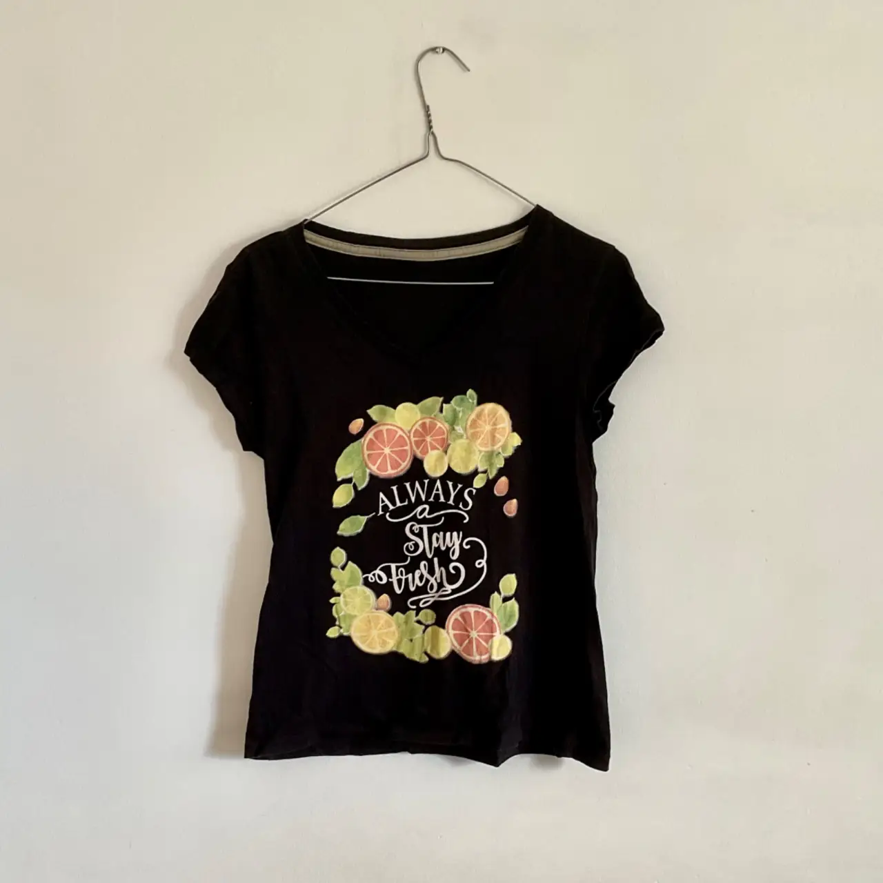 Remera negra de manga corta con estampado "Always Stay Fresh" con diseño de frutas y letras en blanco. Ideal para un look casual y fresco.