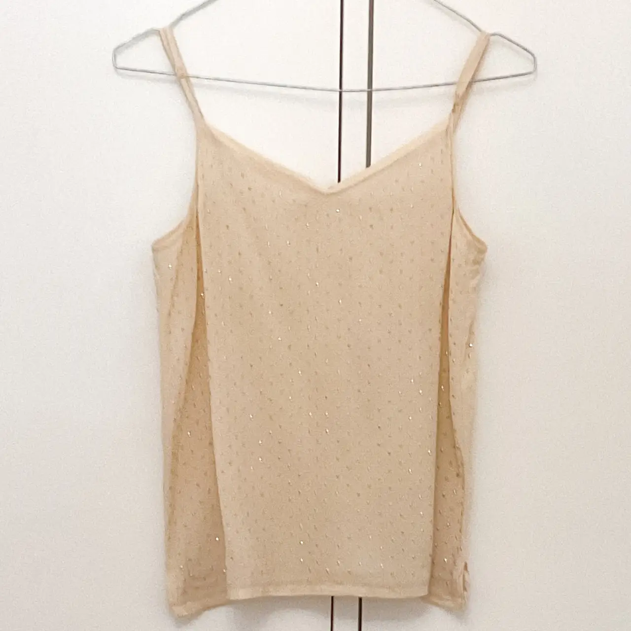 Top de tirantes finos color crudo con detalles brillantes. Ideal para un look elegante y fresco.