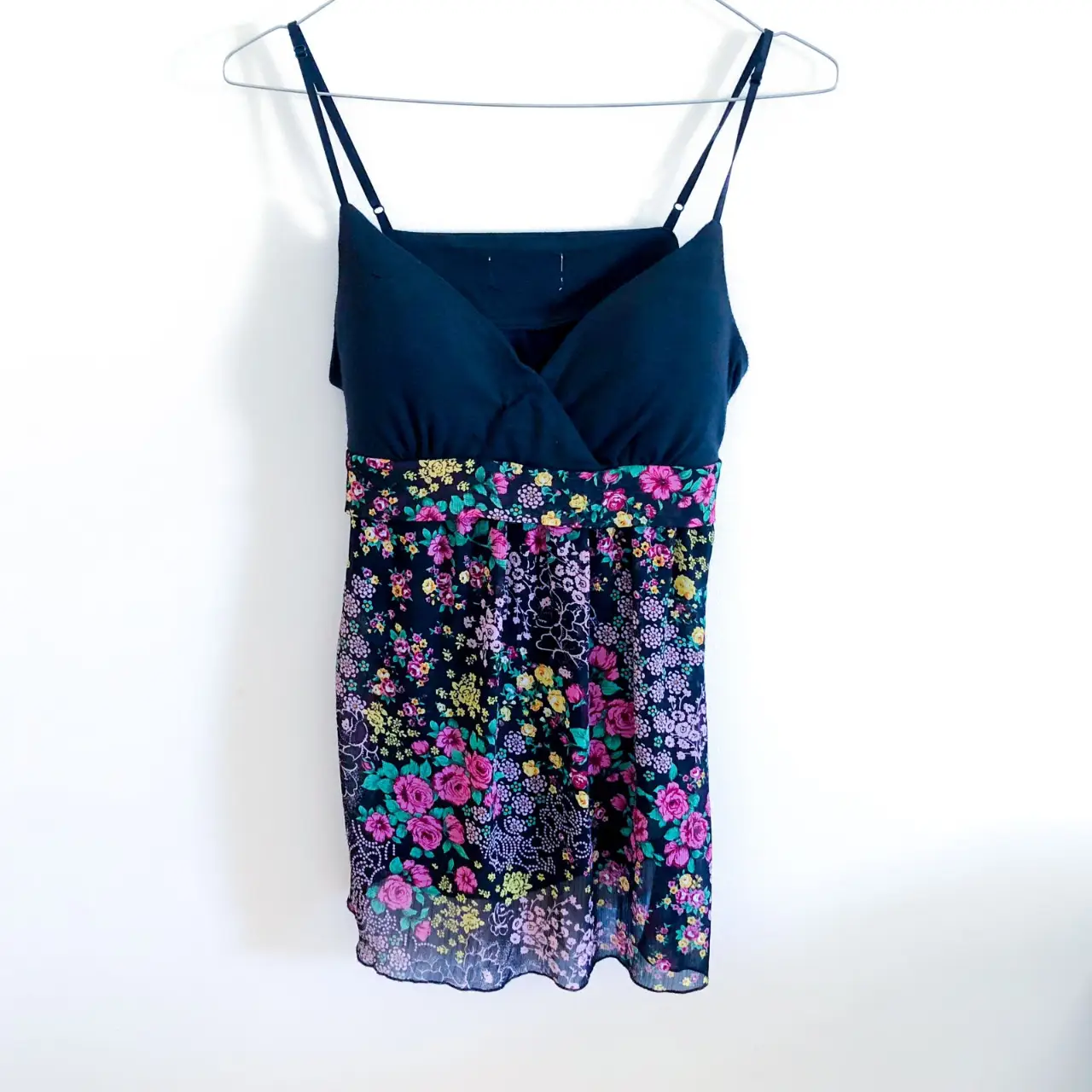 Top de mujer con corpiño negro y detalle floral en la parte inferior. Ideal para un look fresco y femenino.