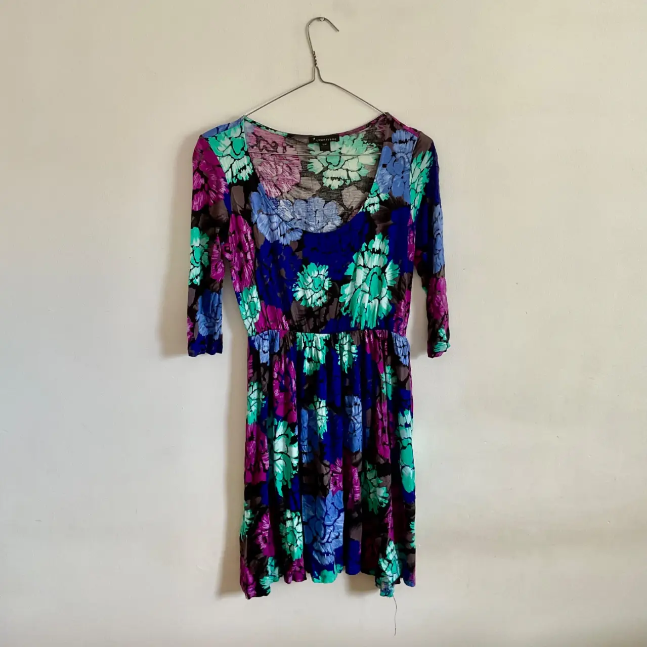Vestido midi con estampado floral en tonos vibrantes. Corte a la cintura y mangas 3/4. Ideal para un look fresco y femenino.