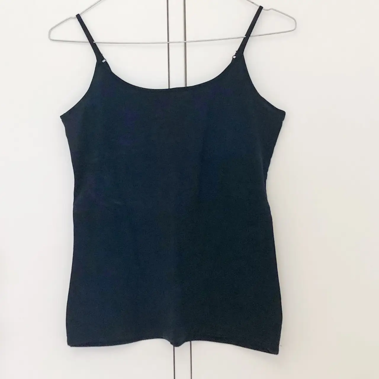 Musculosa negra de tirantes finos, ideal para combinar con cualquier outfit. Perfecta para un look casual o para usar debajo de otras prendas.