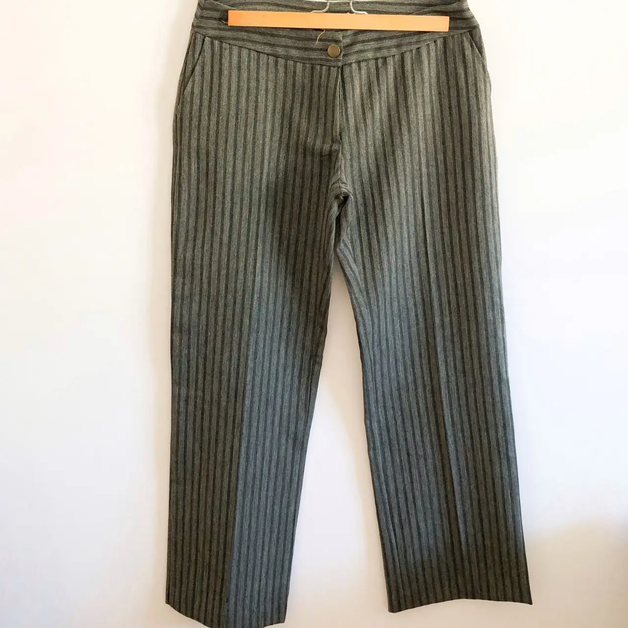Pantalón sastrero de mujer, con diseño a rayas verticales en tono gris. Corte recto y elegante, ideal para un look formal o de trabajo.
