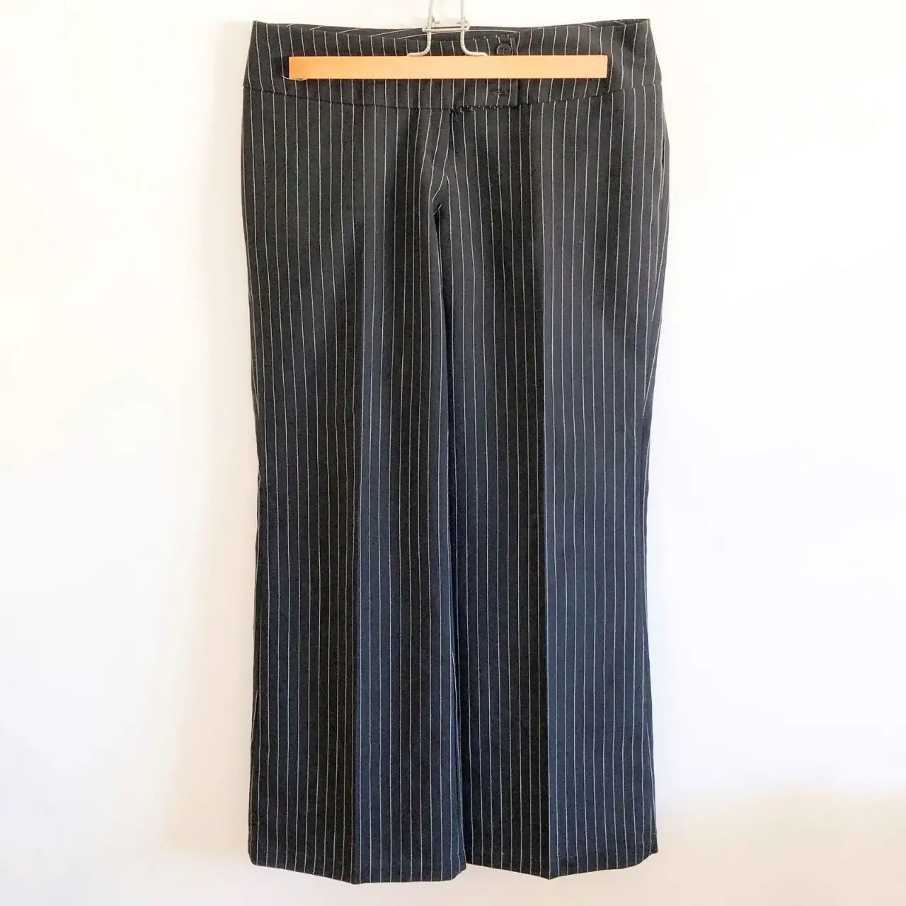 Pantalón sastrero de mujer, negro con finas rayas blancas verticales. Corte recto y elegante, ideal para un look formal o de trabajo. Confeccionado en tejido de calidad.