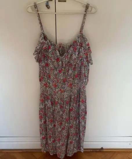 Vestido corto de verano con estampado floral. Tiene tiras finas ajustables y un detalle de volados en el pecho. La cintura es elastizada para mayor comodidad.