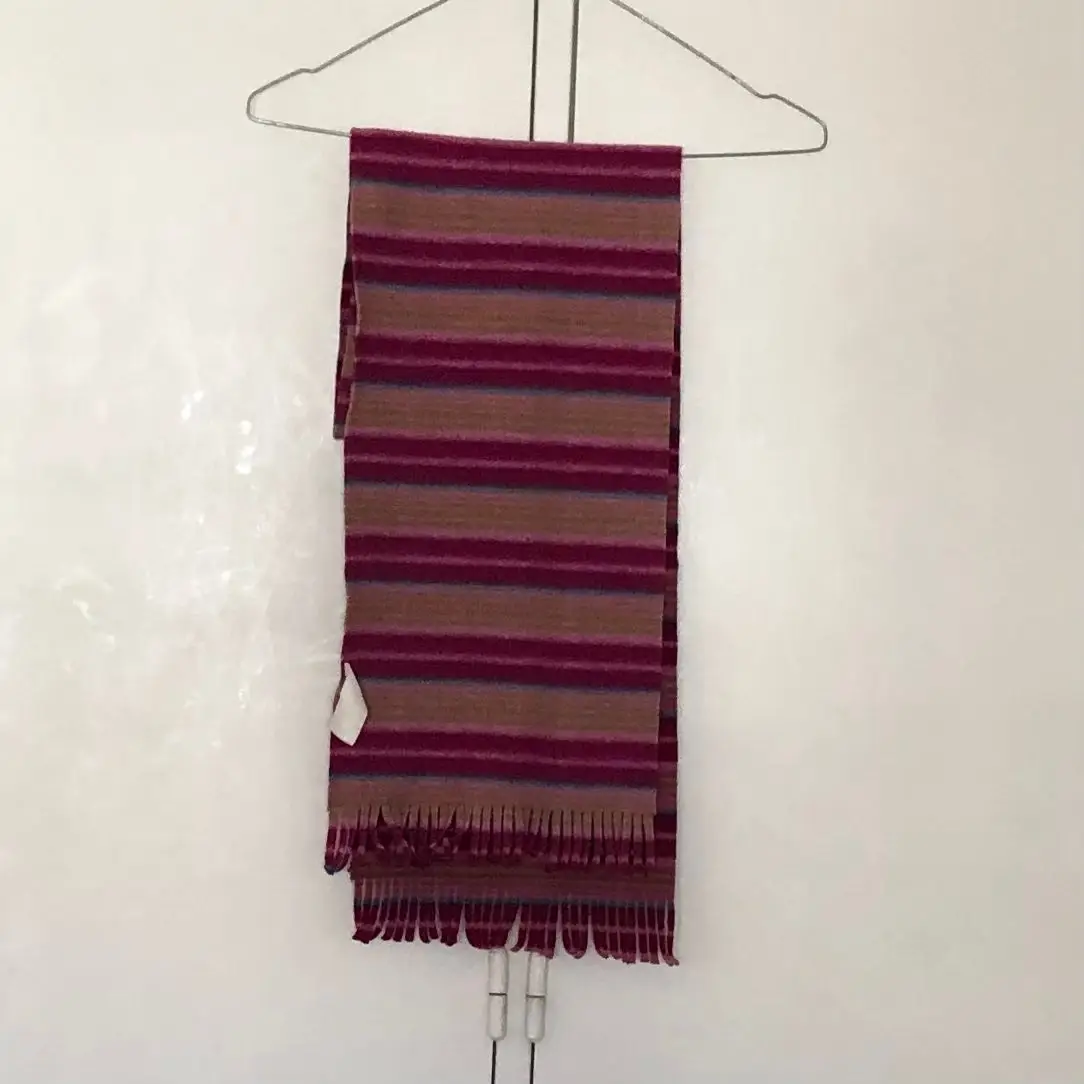 Bufanda a rayas en tonos marrones y bordó, ideal para el invierno. Con flecos en los extremos.