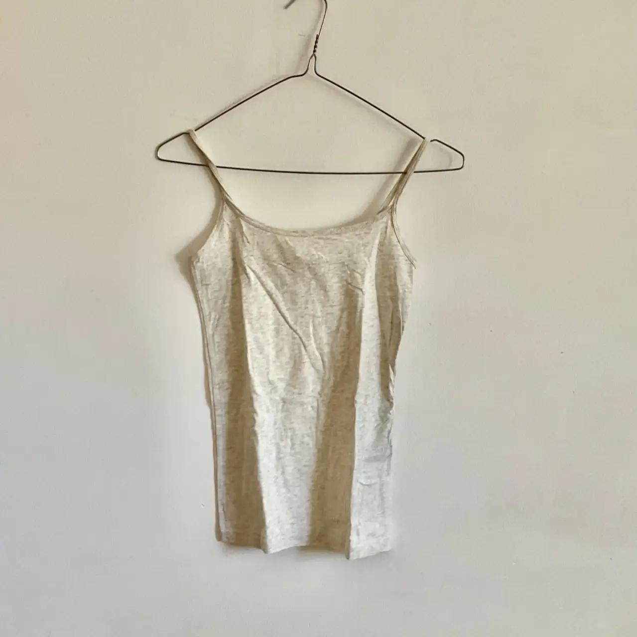 Musculosa de tirantes finos en color gris claro, ideal para usar debajo de otras prendas o como top básico. Confeccionada en un tejido suave y ligero, perfecta para el día a día.