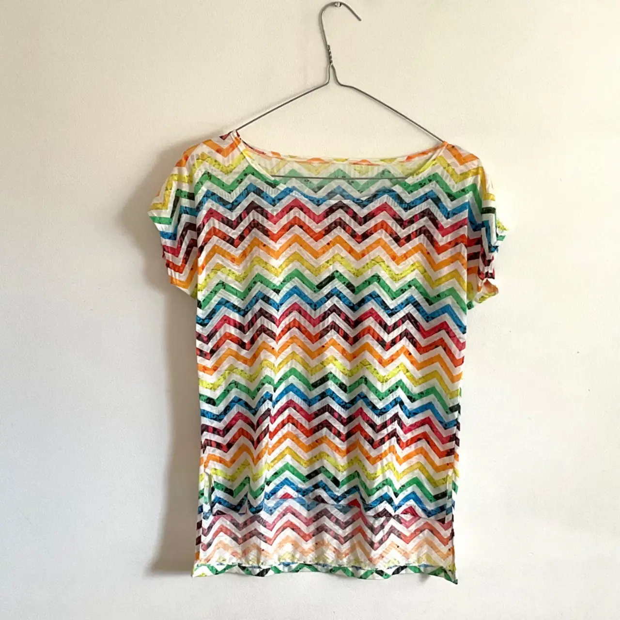 Remera de manga corta con estampado de chevron multicolor. Ideal para un look casual y fresco.