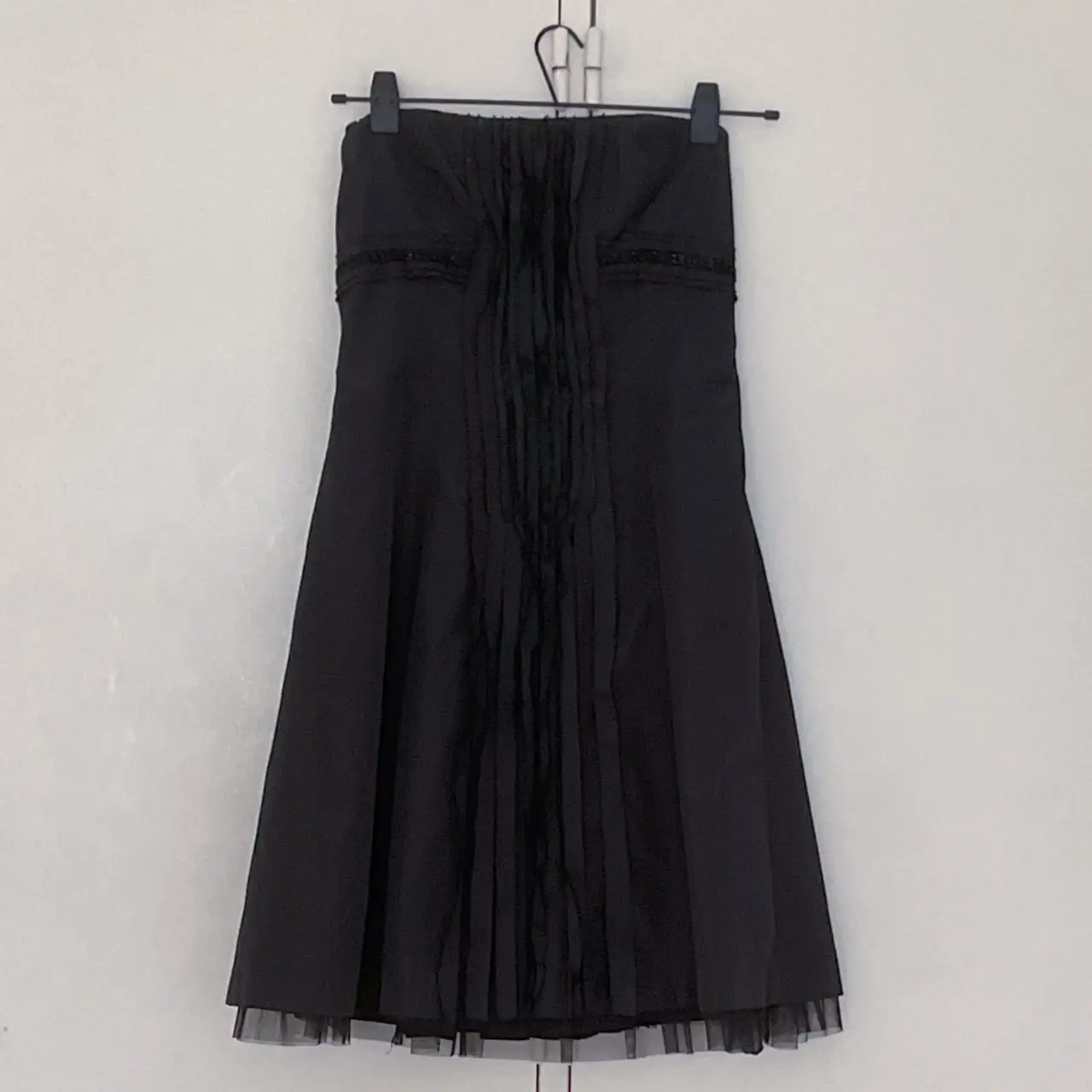 Vestido strapless negro, ideal para eventos formales o fiestas. Diseño elegante con detalles plisados y falda con tul.