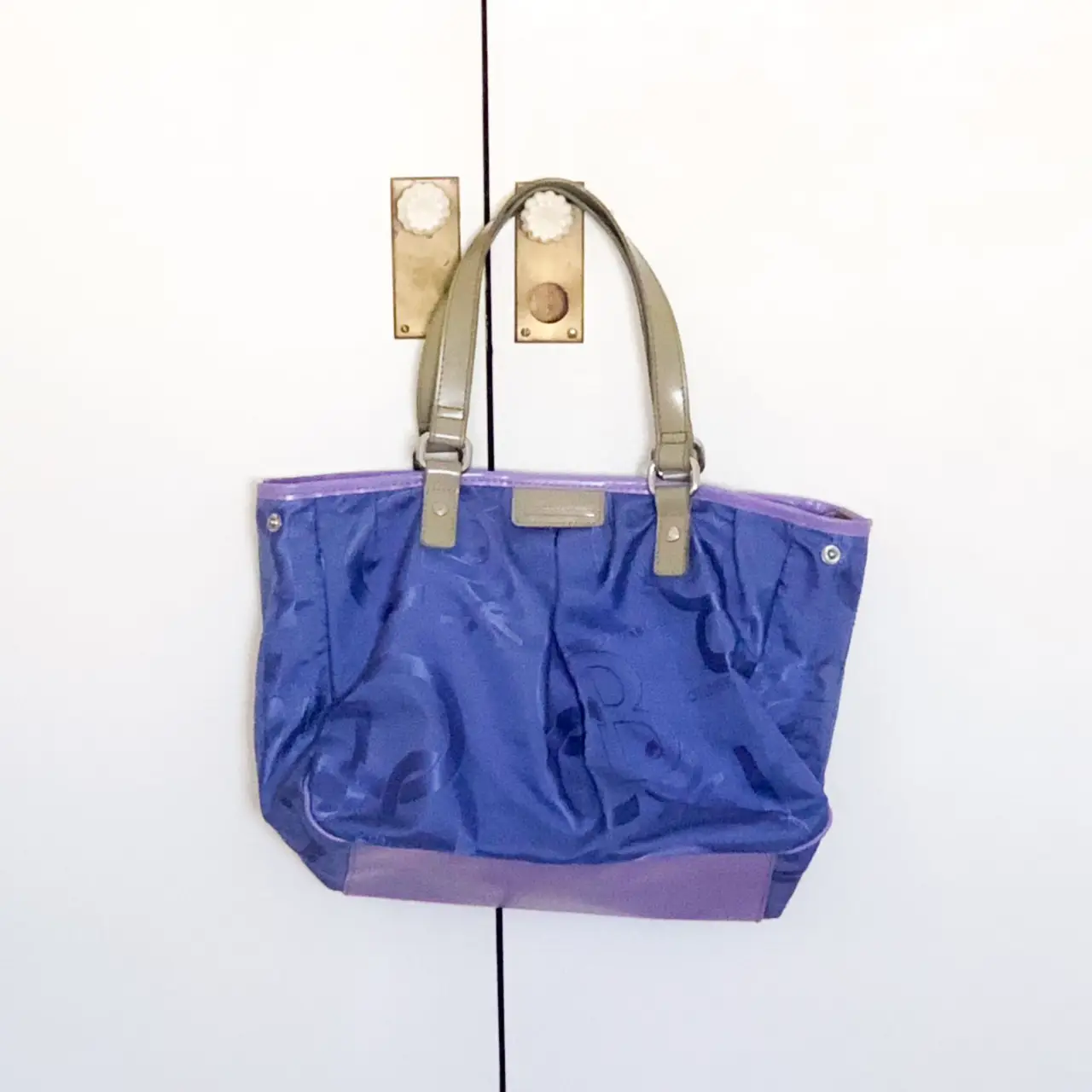 Cartera tote bag azul con detalles en violeta y manijas en color gris. Ideal para llevar todo lo que necesitas con estilo.
