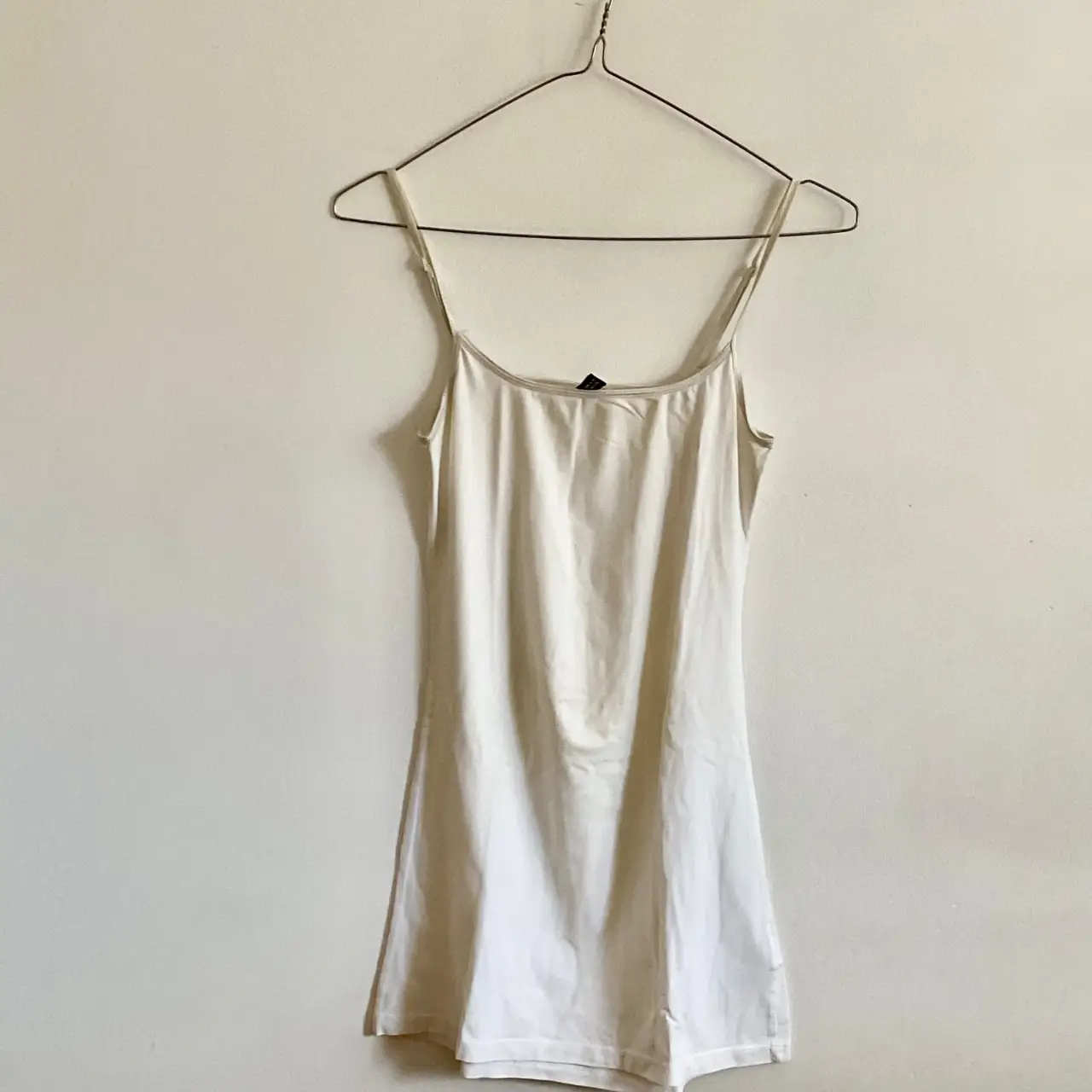 Vestido mini blanco de tirantes finos, ideal para el verano. Perfecto para un look casual y fresco.