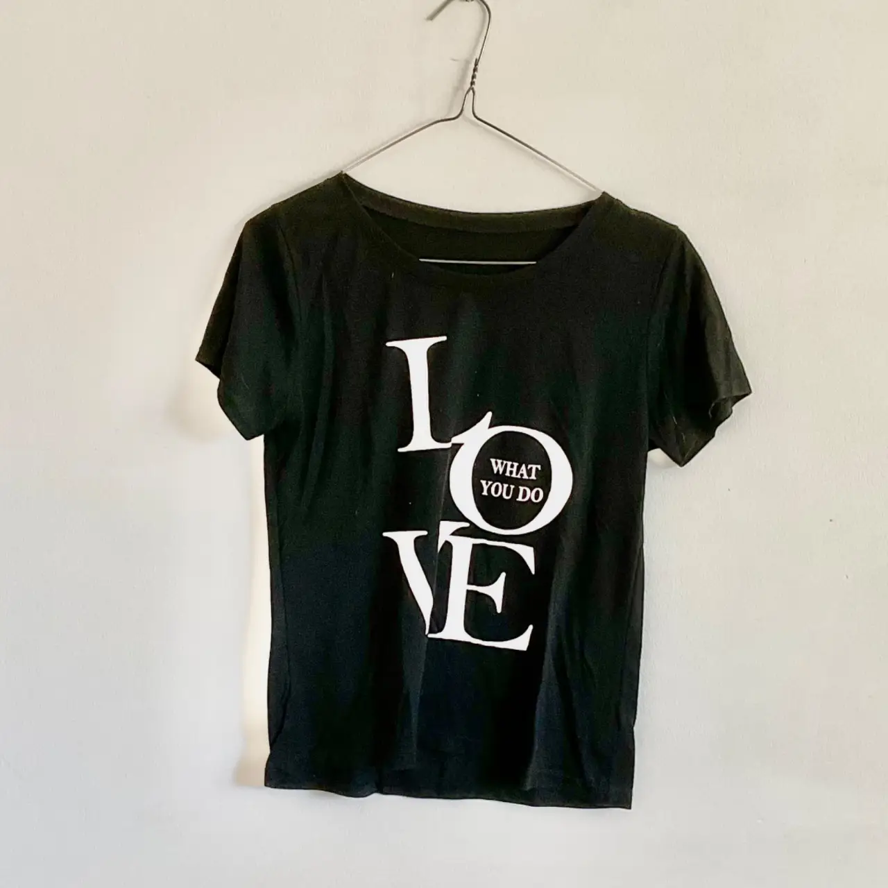 Remera negra de algodón con estampado "LOVE WHAT YOU DO" en blanco. Ideal para un look casual y moderno.