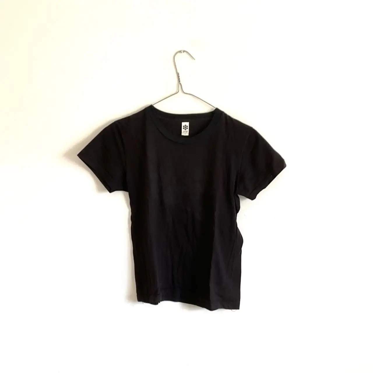 Remera negra de algodón, de corte clásico y manga corta. Ideal para un look casual y versátil.