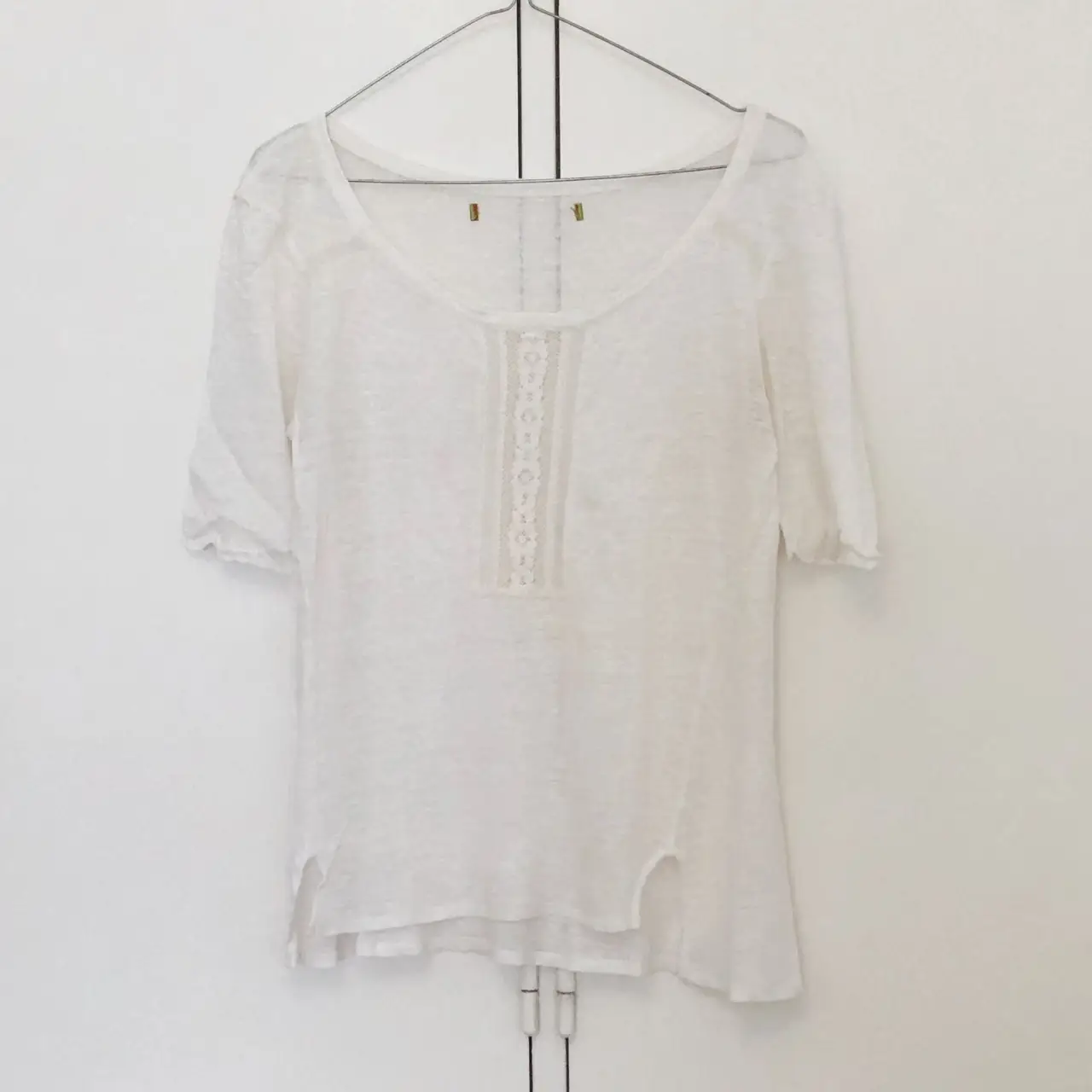 Blusa blanca de lino con detalle de encaje en el frente. Ideal para un look casual y fresco.