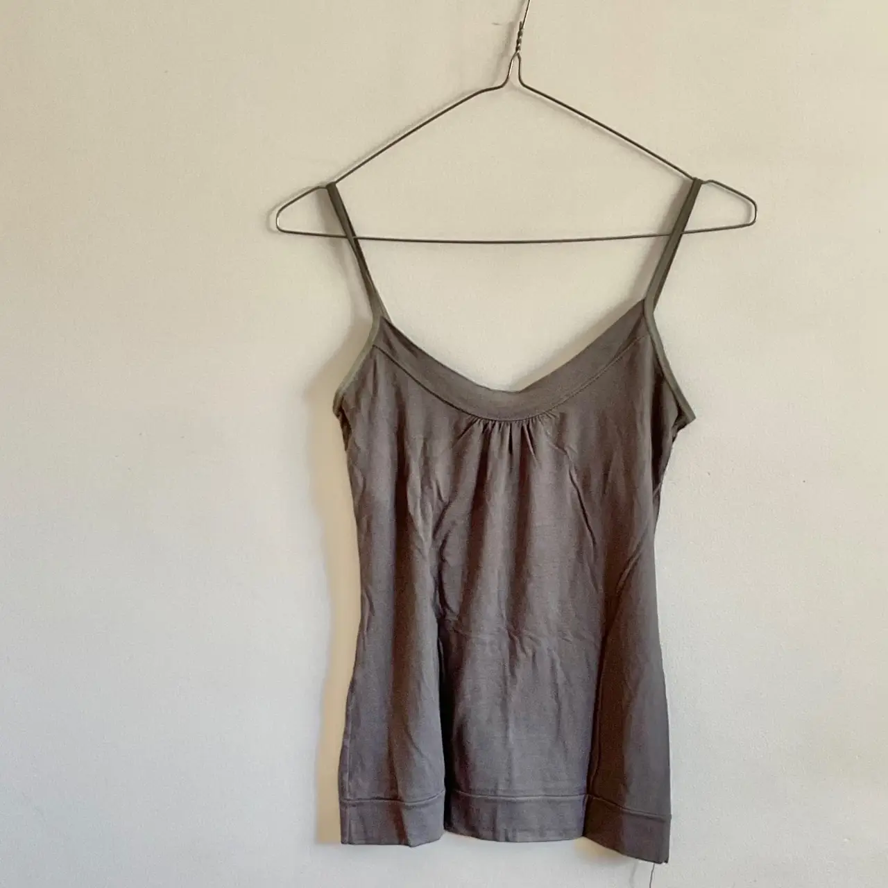 Musculosa gris con breteles finos, ideal para un look casual y fresco. Perfecta para combinar con jeans o shorts.