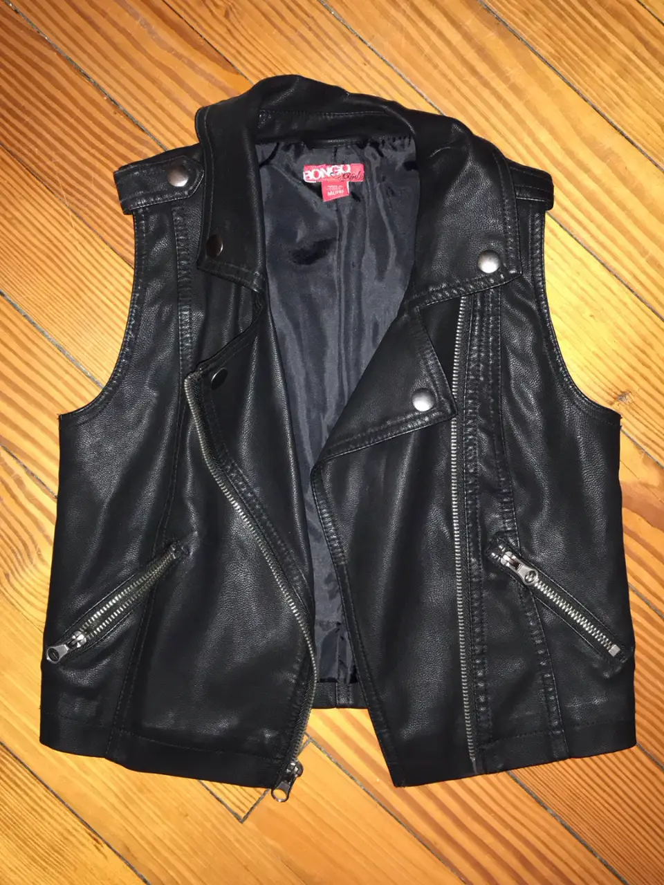 Chaleco de cuero sintético negro, estilo biker, con cierre y detalles metálicos. Ideal para un look rocker o casual.