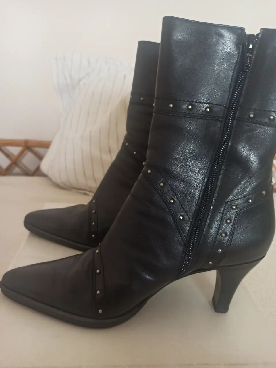 Botas de cuero negro con detalles de tachas plateadas. Diseño elegante con cierre lateral y taco fino. Ideales para un look sofisticado.
