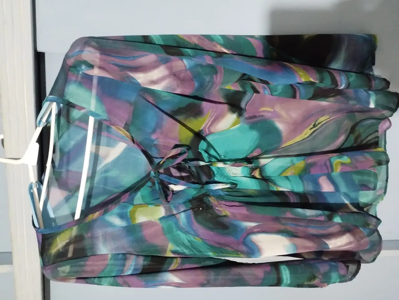 Blusa de mujer con estampado abstracto en tonos turquesa, violeta y verde, en gasa. Diseño fluido y elegante, ideal para un look sofisticado y moderno.