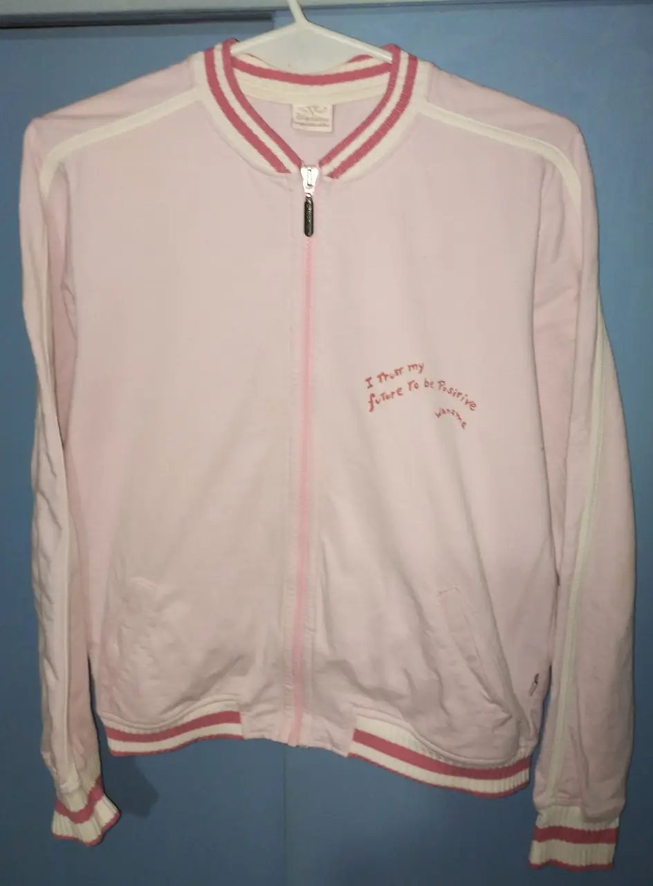 Campera deportiva de mujer en color rosa con detalles en blanco. Material algodón rústico sin Friza. Tiene cierre frontal y puños con ribete. En el frente tiene una frase estampada. Ideal para un look casual y cómodo. Sisa 59 CM, largo total 55 CM, largo de mangas 60