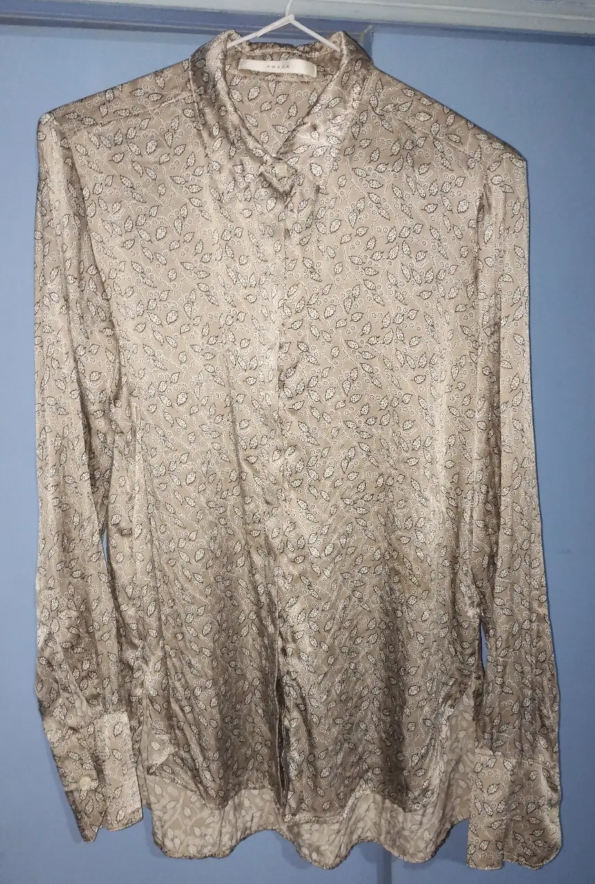 Camisa de mujer AWADA, en raso de seda, con estampado de hojas en color crudo. Ideal para un look elegante y sofisticado. Sisa 36 CM, largo total 64 CM, largo de mangas 60 CM 