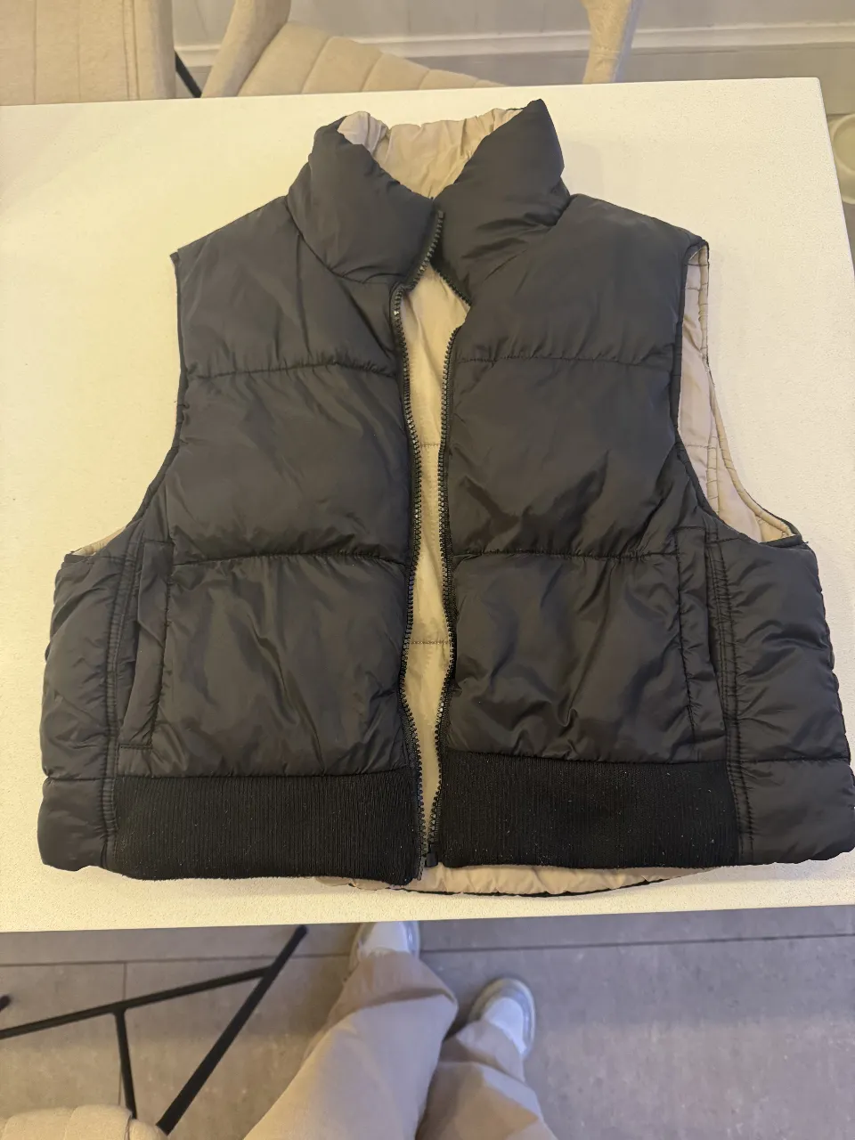 Chaleco reversible acolchado para mujer, con cierre y cuello alto. Un lado es negro y el otro color crudo. Ideal para el invierno.