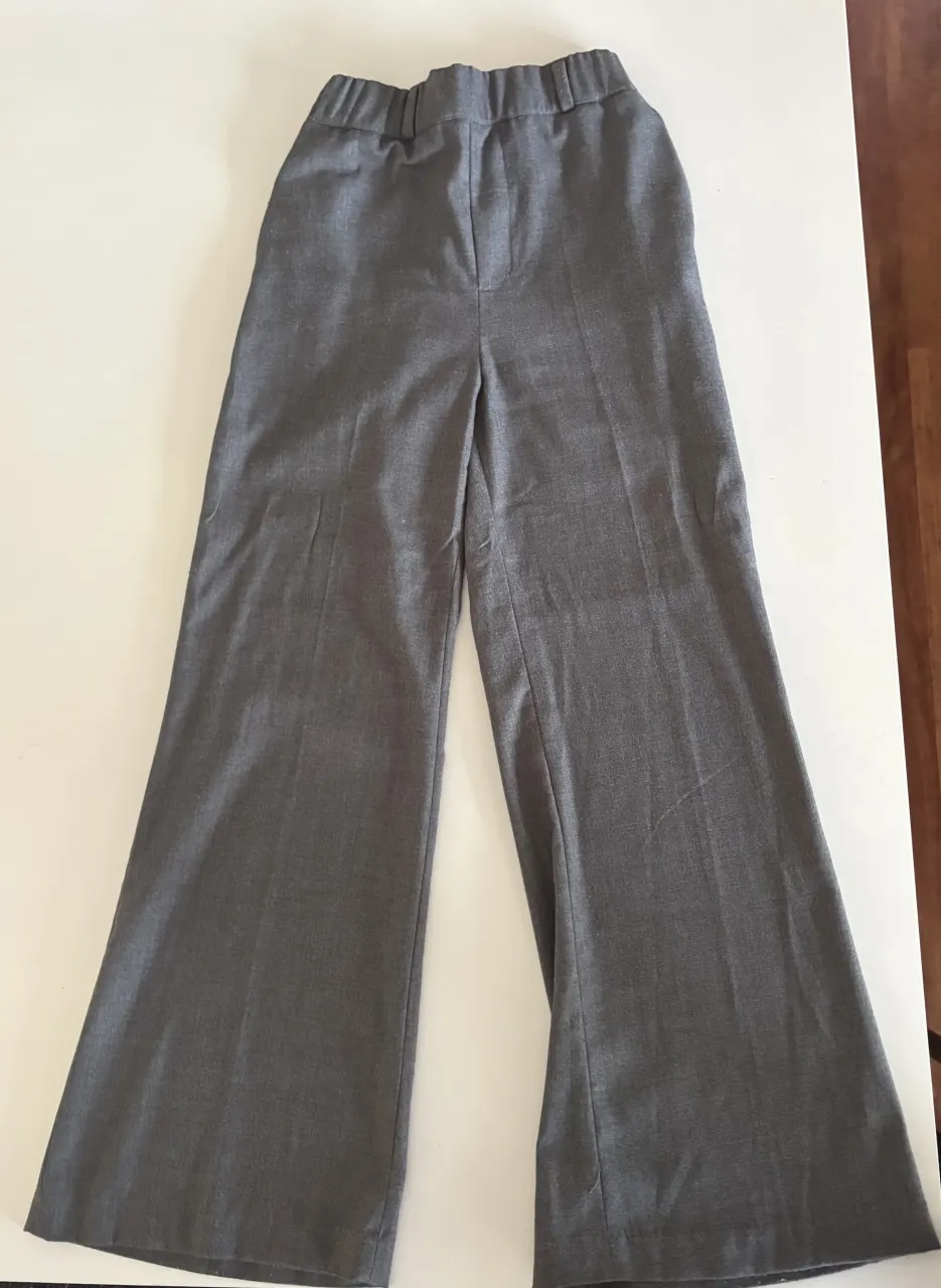 Pantalón gris con cintura elastizada y bolsillos.
