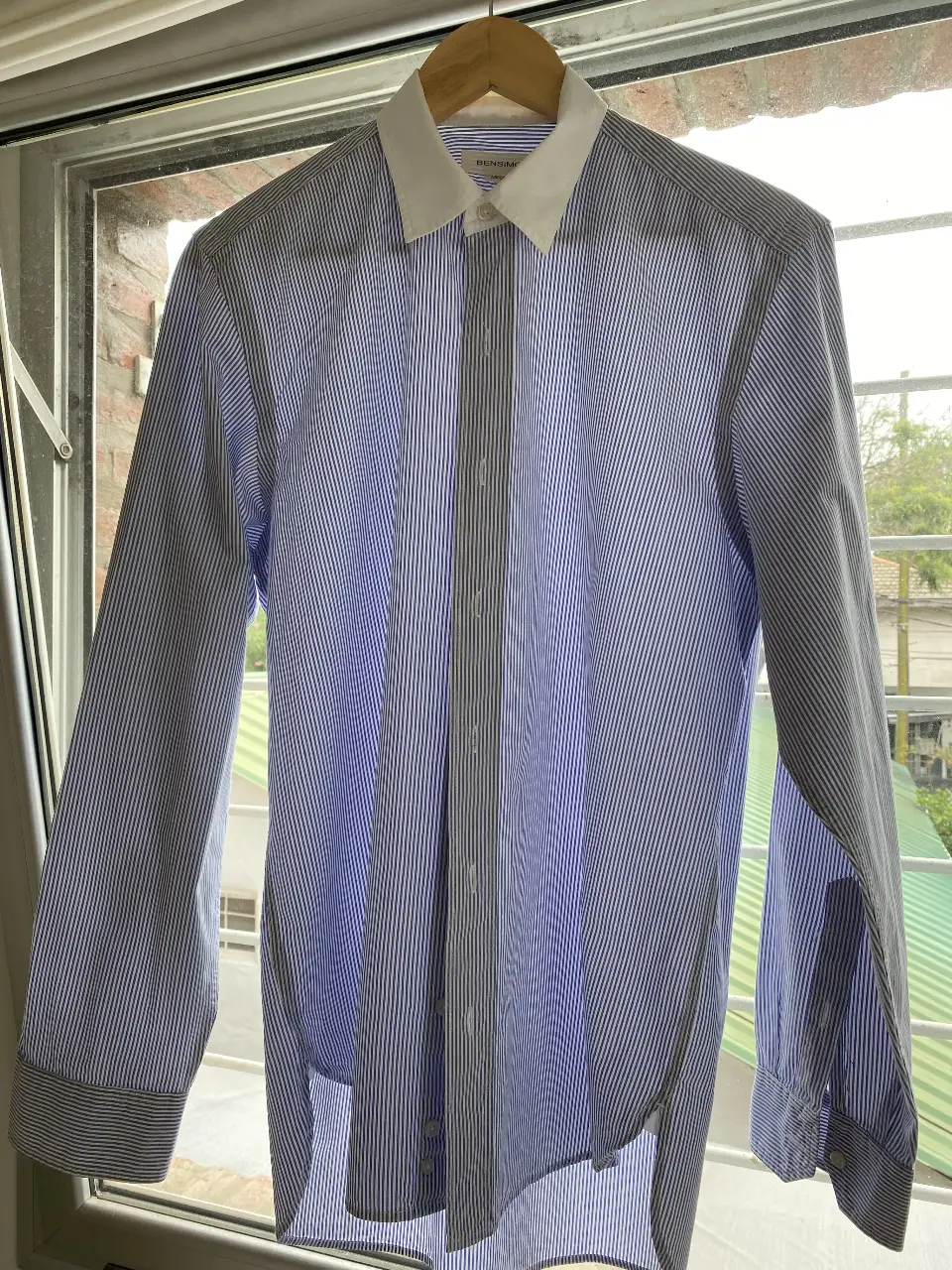 Camisa a rayas azul y blanca de hombre, con cuello blanco y corte clásico. Ideal para un look casual o de trabajo.