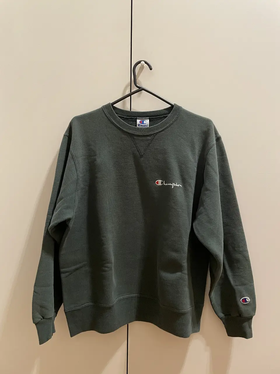 Buzo Champion vintage de cuello redondo en color verde oscuro. 100% algodon. Con el logo de la marca bordado en el pecho y en la manga. Ideal para un look casual y cómodo. 