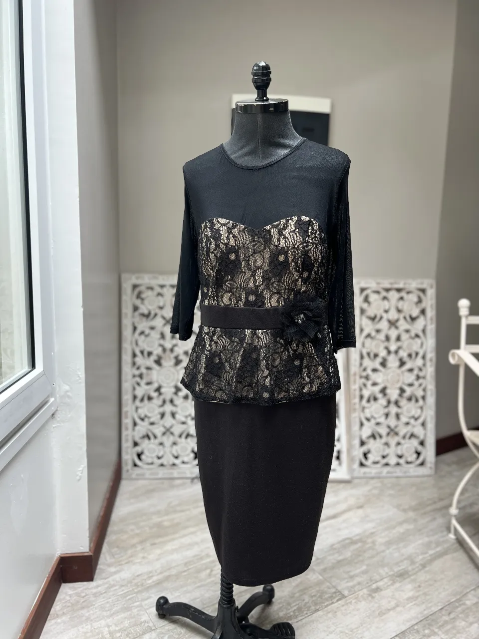 Vestido midi negro con detalles de encaje en la parte superior y falda. Ideal para eventos formales o fiestas.