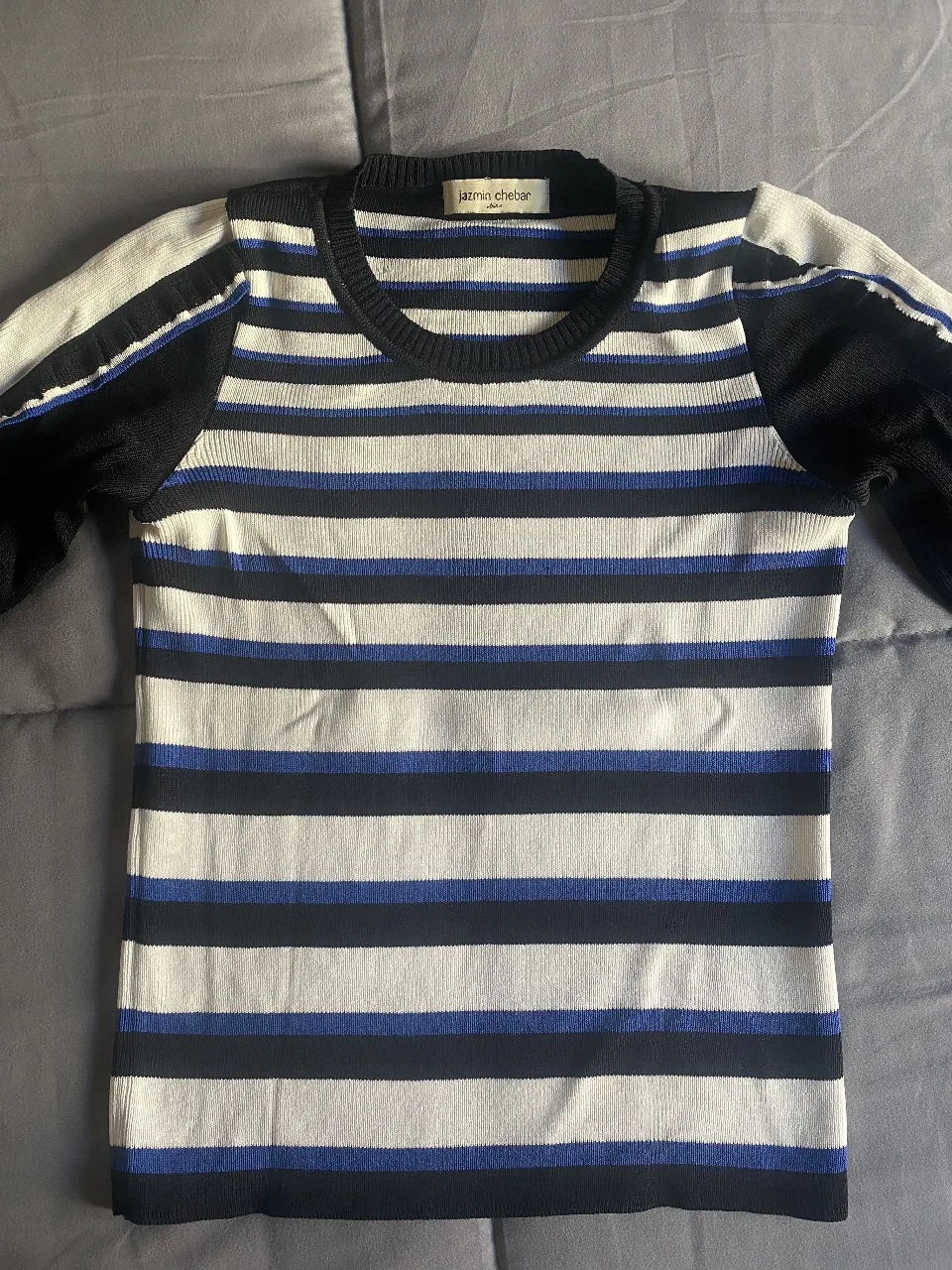 Sweater de mujer a rayas horizontales en blanco, negro y azul. Cuello redondo y mangas con volados. Marca Jazmin Chebar.